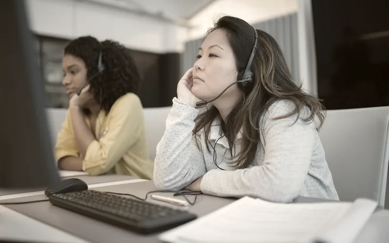 A headset resting on a desk in a call centre