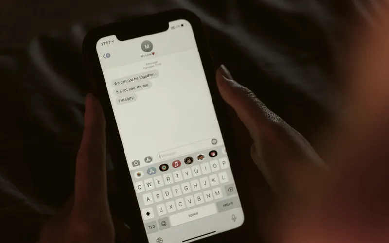 A hand holding a smartphone showing a message