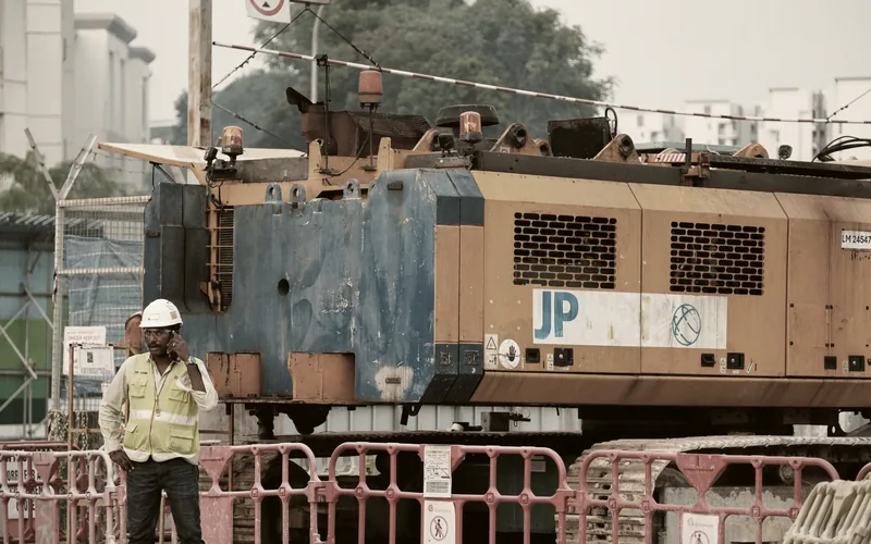 A worker on a construction site holding a phone